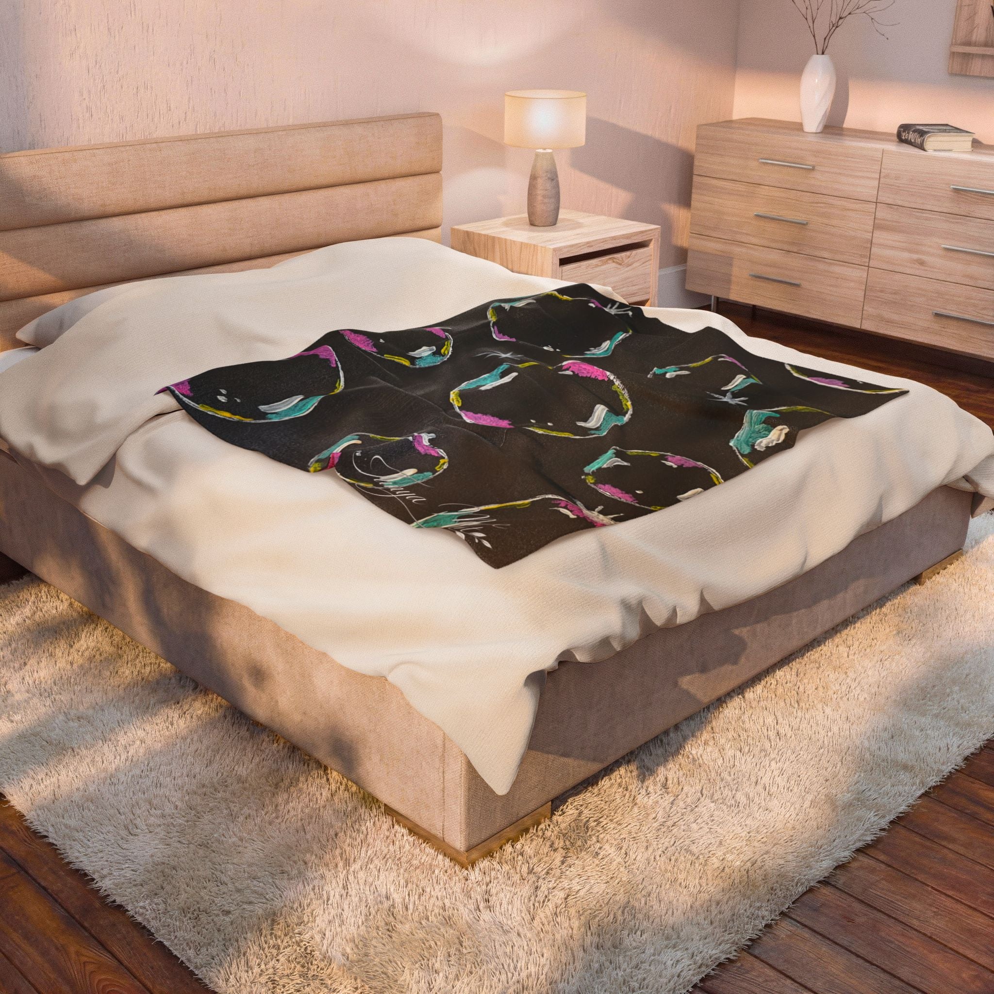 Black velveteen plush blanket with colorful bubble ring print on bed