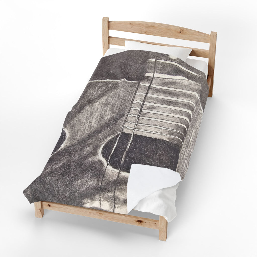 Velveteen plush blanket draped over bed, gray guitar outline with white string lines