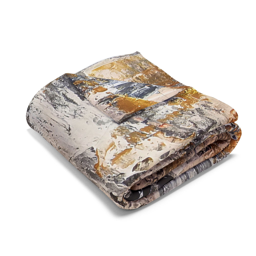 Folded fleece blanket with abstract grey, gold, and black circle artwork, angled view