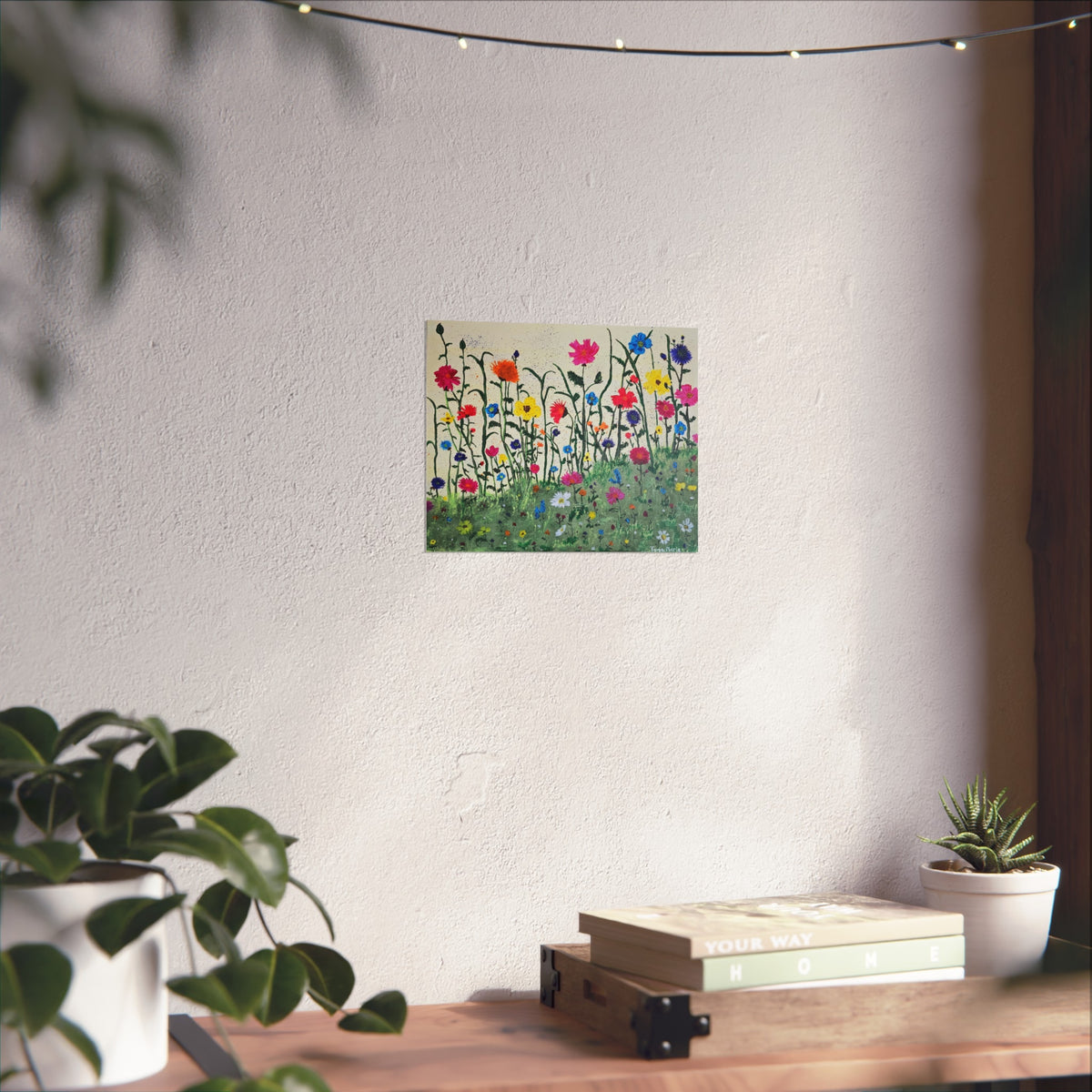 Matte wildflower meadow poster on wall above wooden console table and potted plant