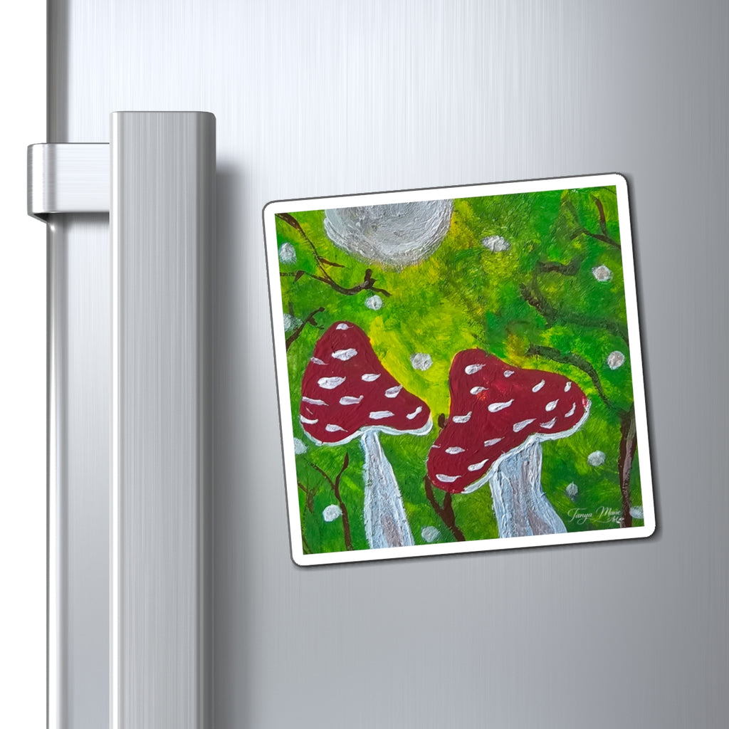Red toadstool art magnet on a stainless fridge door with gray moon and green forest