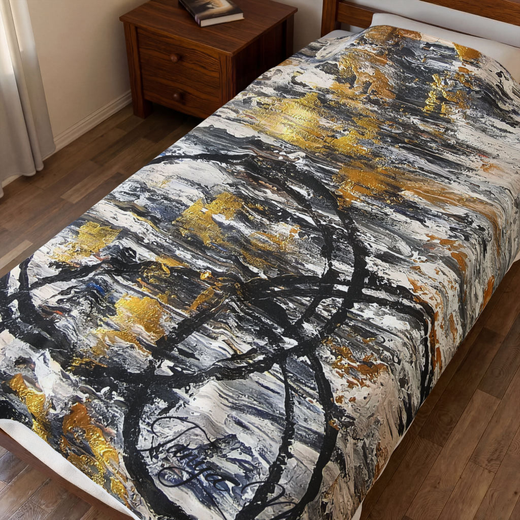 Velveteen plush blanket with bold gold, charcoal, and white abstract circle pattern