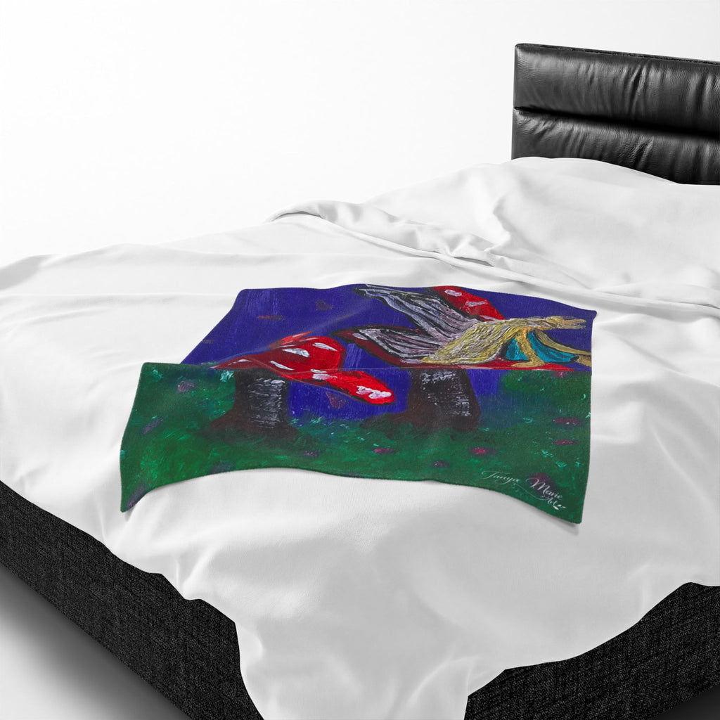 White plush throw blanket with close-up fairy and red toadstool artwork centered