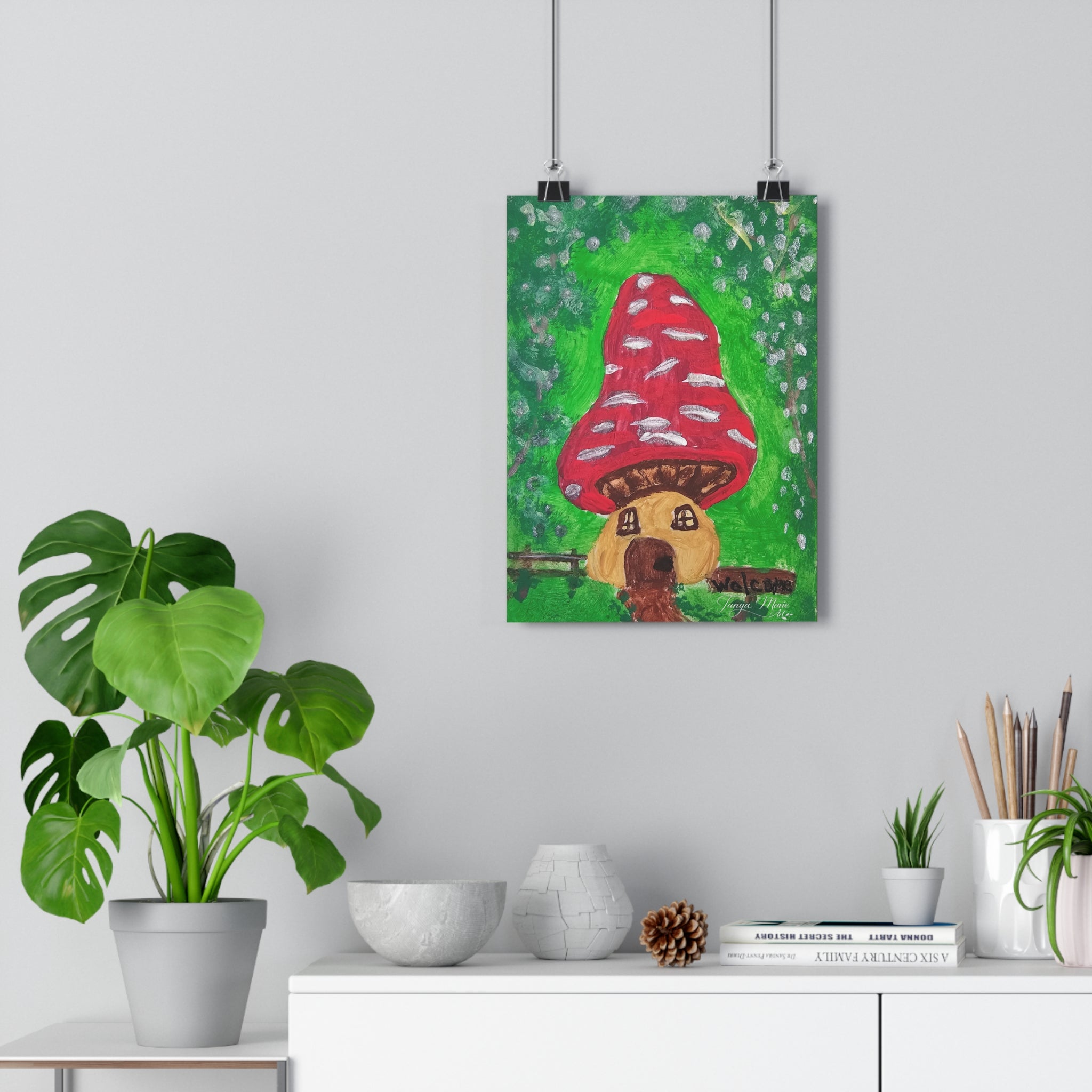 Hanging wall art print with red spotted mushroom house and brown dog