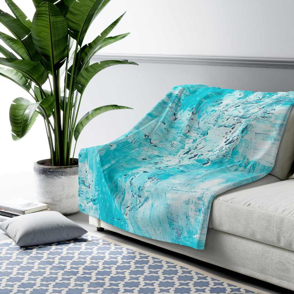Turquoise abstract sherpa blanket draped on couch, teal and white textured artwork