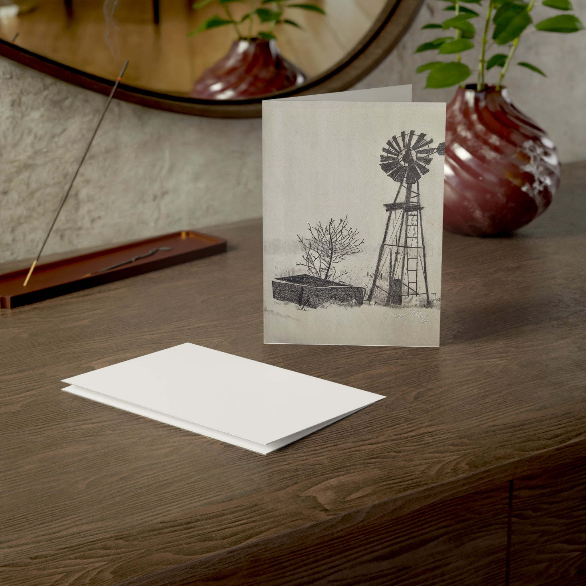 White greeting card front with centered windmill sketch and small landscape, rectangular