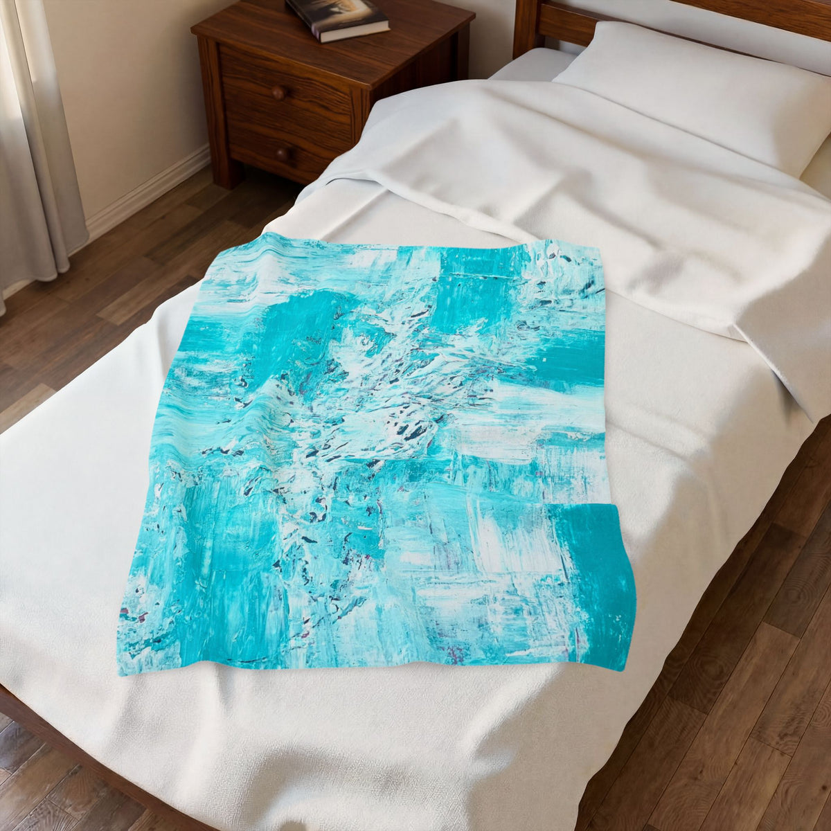 Turquoise abstract plush blanket on bed, folded piece on white sheets