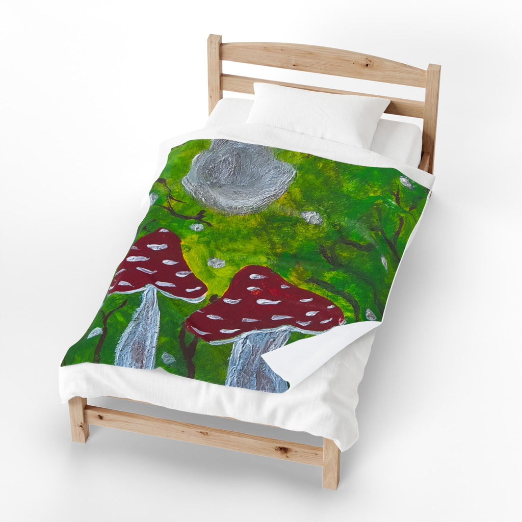 Plush velveteen blanket on bed, green woodland scene with red mushrooms and gray rocks