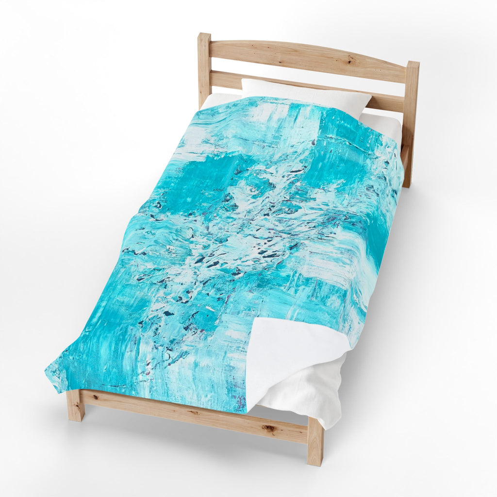Turquoise abstract plush blanket on wooden bed frame, white underlayer visible