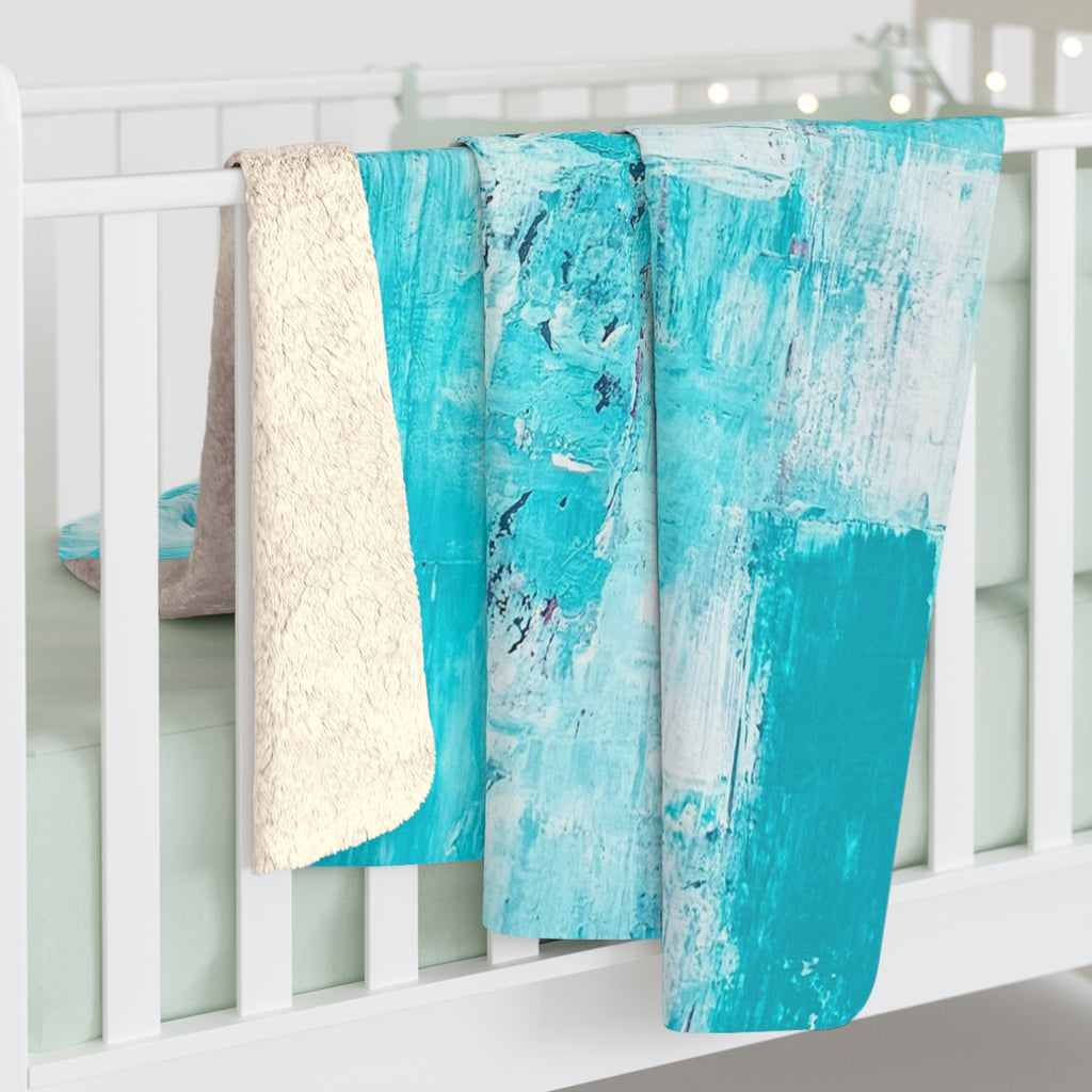 Turquoise abstract sherpa blanket draped over railing, showing off-white sherpa edge