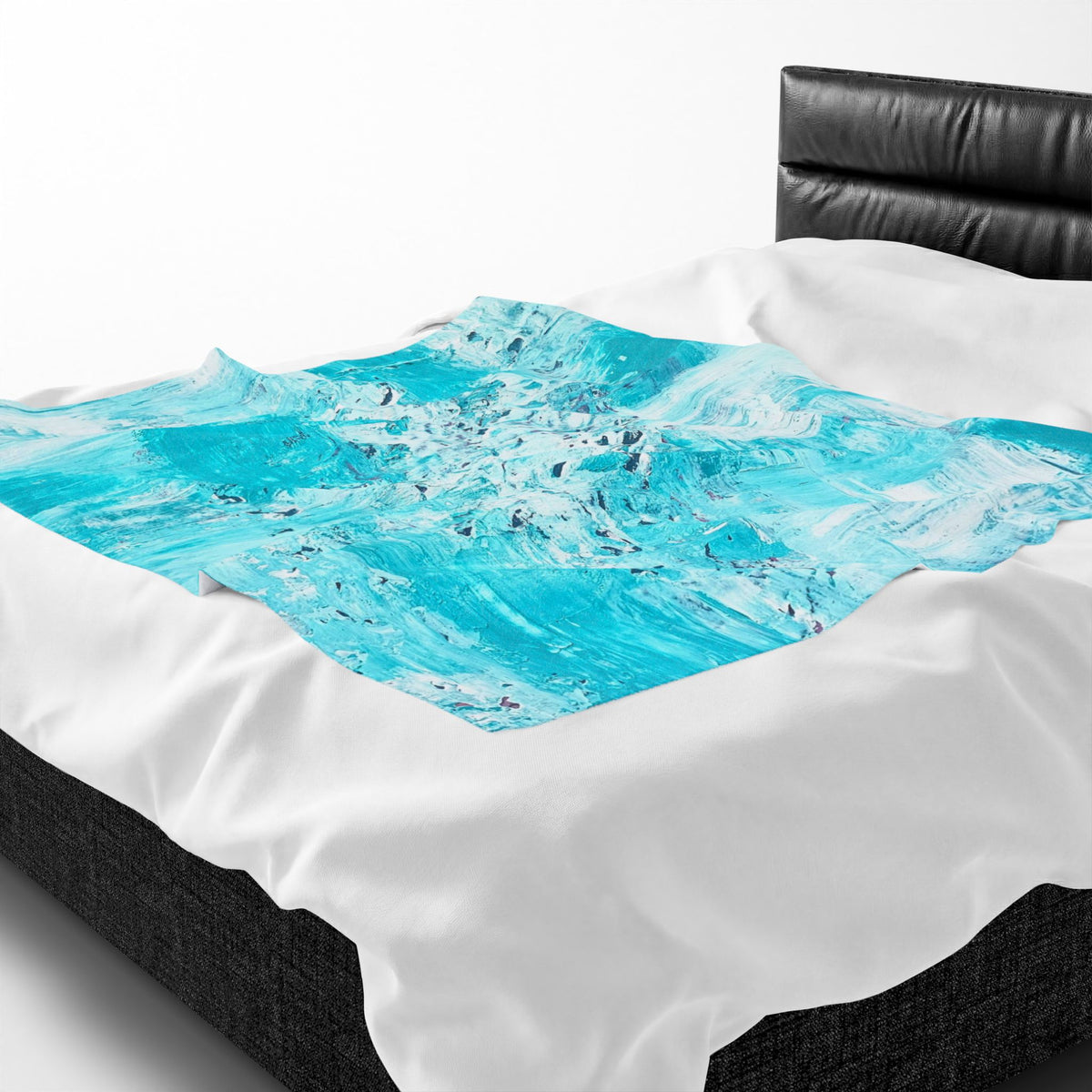 Velveteen plush blanket with turquoise abstract ocean swirl centered on white bedding