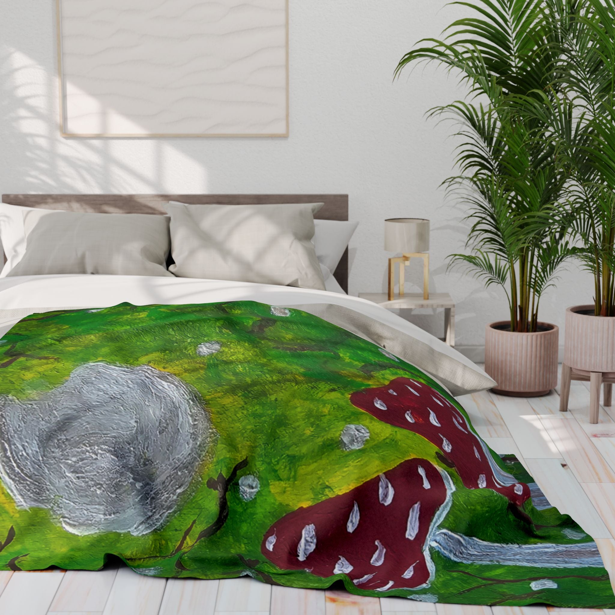 Green fleece blanket laid on bed, with red spotted mushrooms and gray moonlike cap