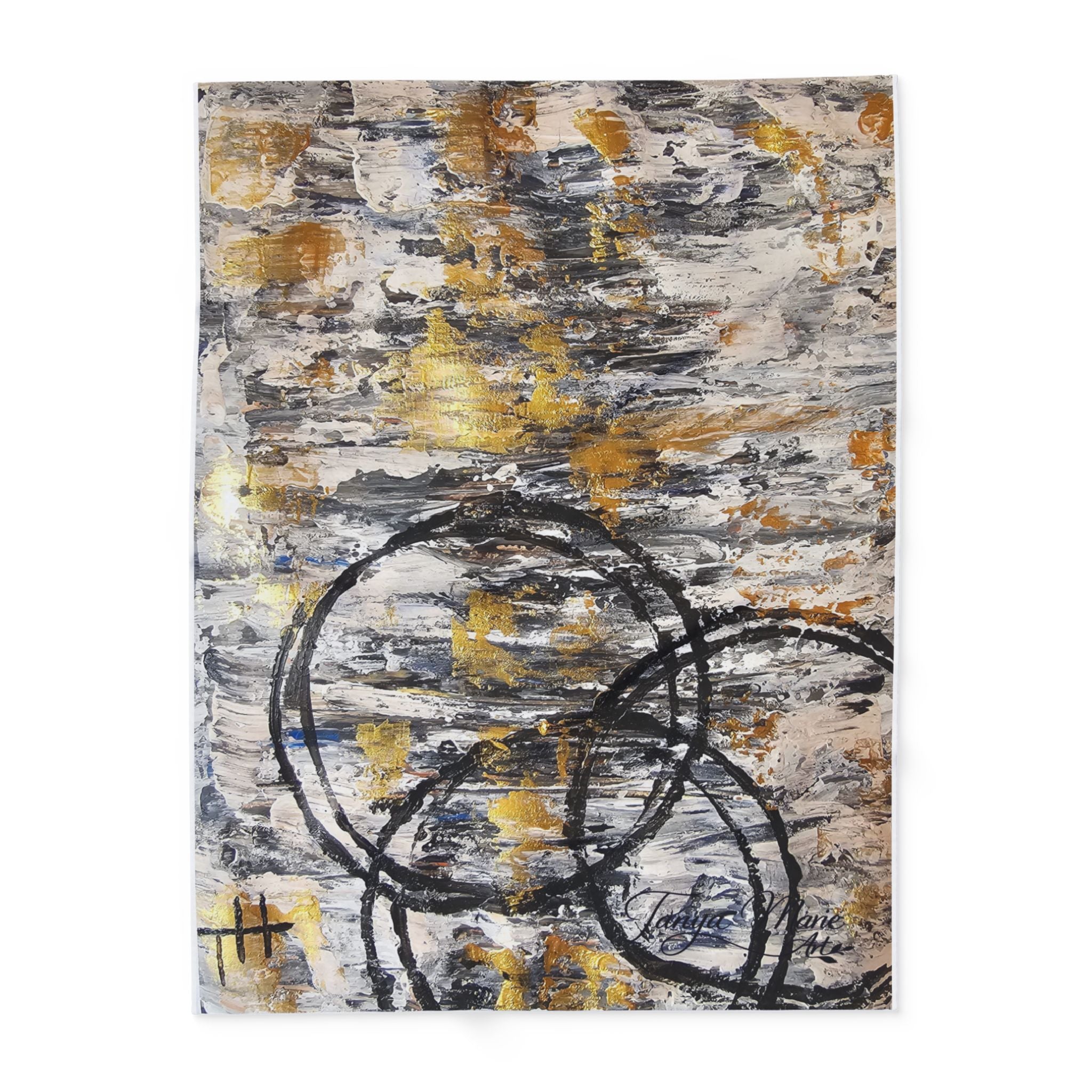 Abstract fleece blanket showing grey, gold, and black circle lines on textured print