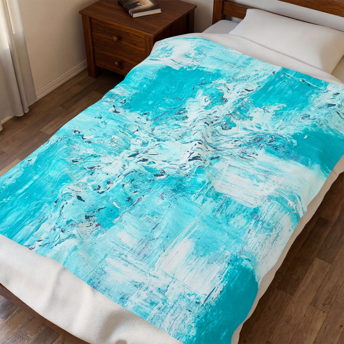 Velveteen plush blanket draped on bed with turquoise abstract splash design