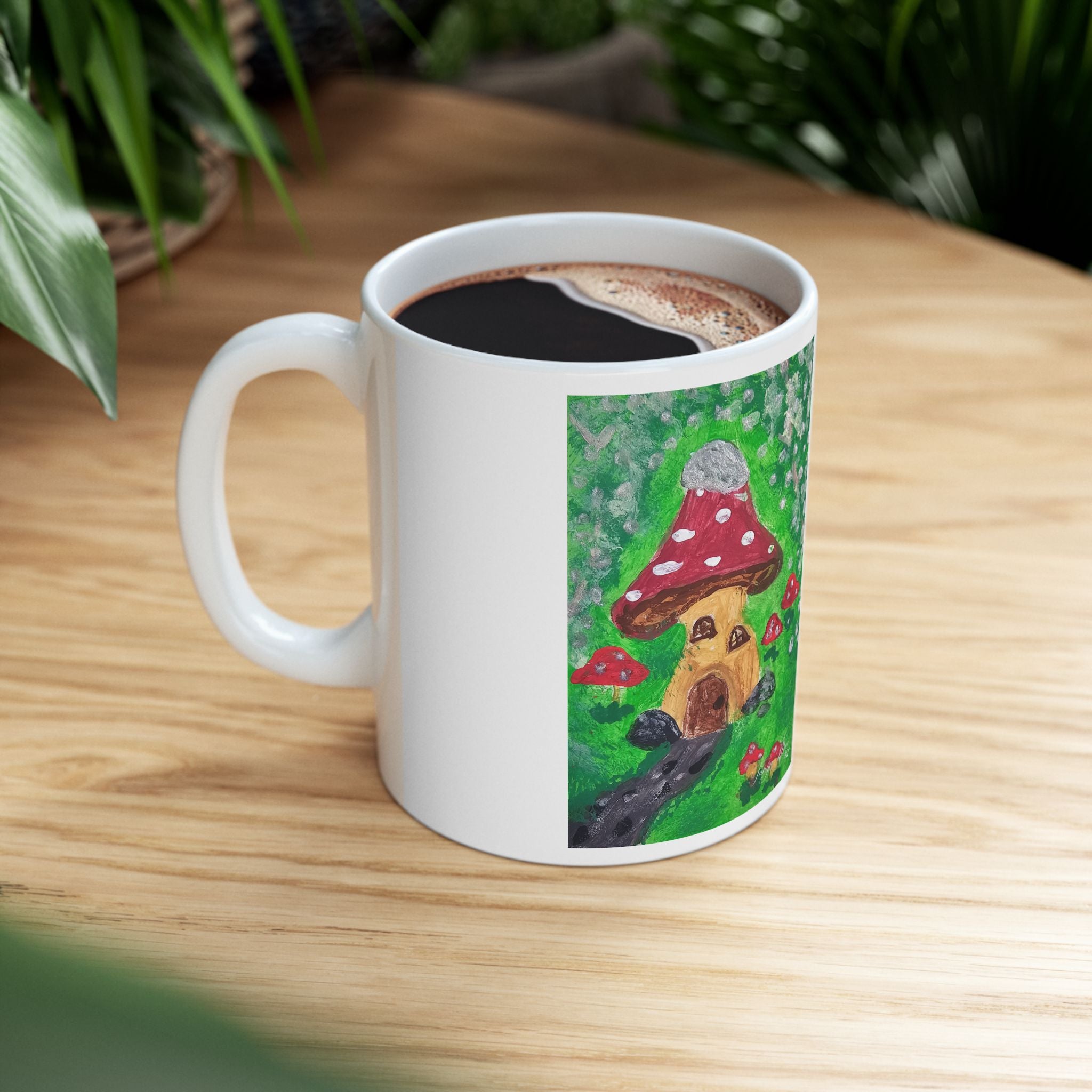 White ceramic mug with mushroom cottage illustration, filled with black coffee
