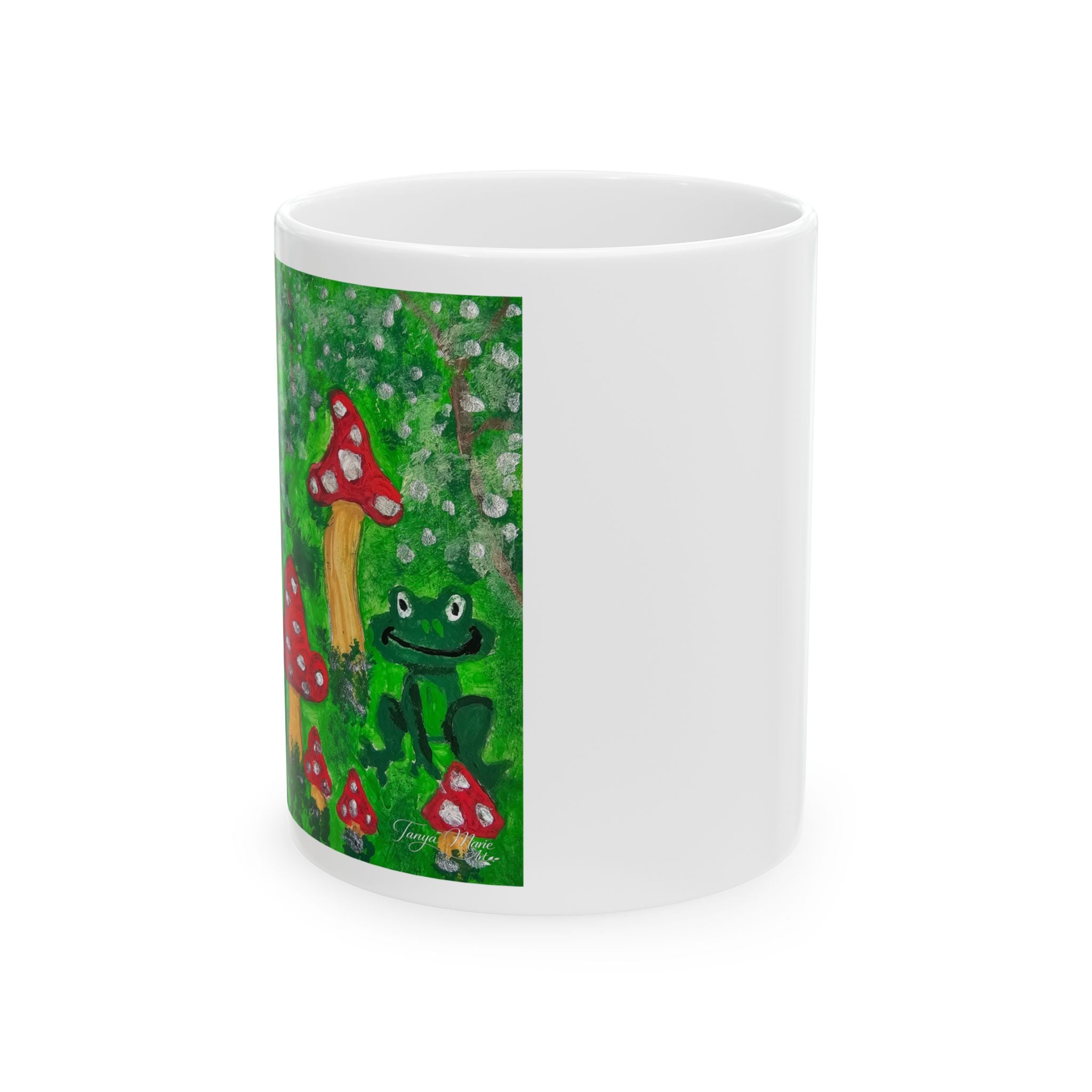 White ceramic mug with printed forest scene, green frog and red toadstools on side