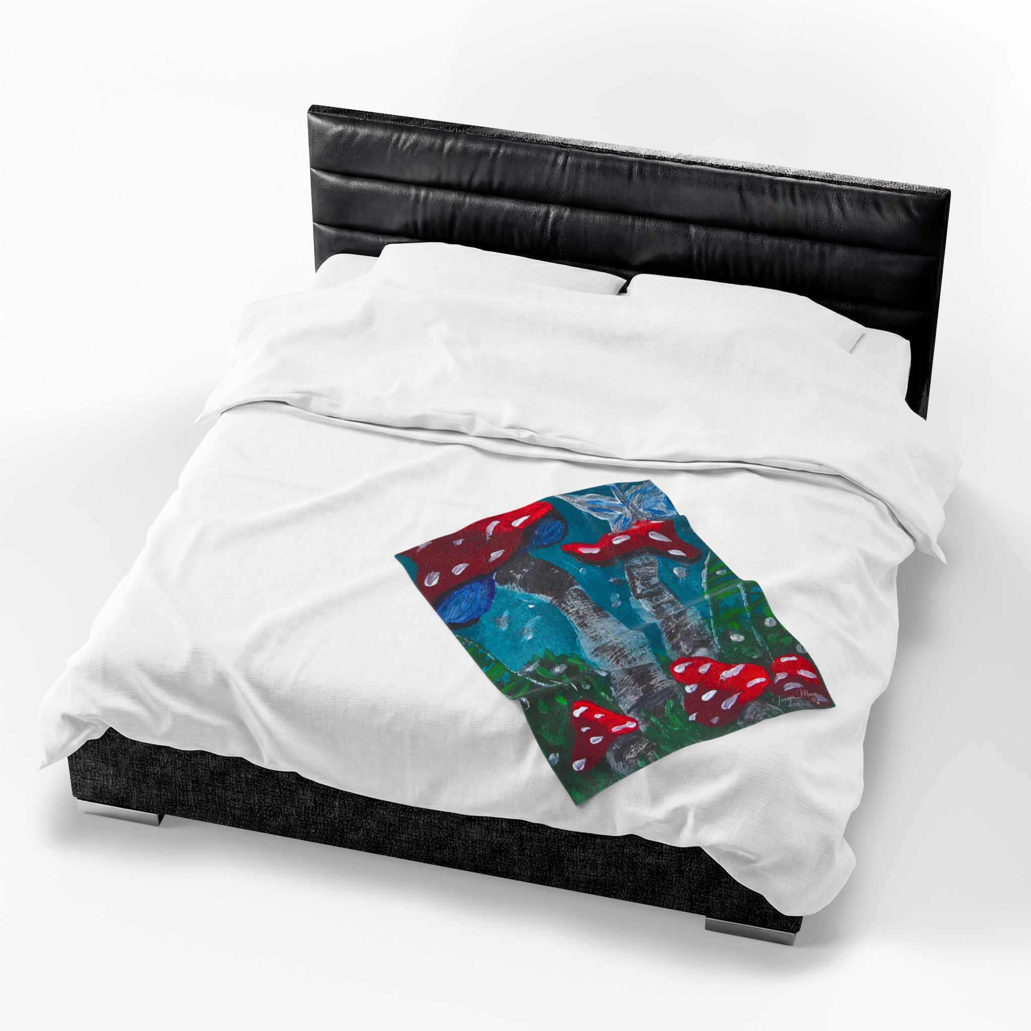 White plush throw blanket on black bed with colorful mushroom print panel