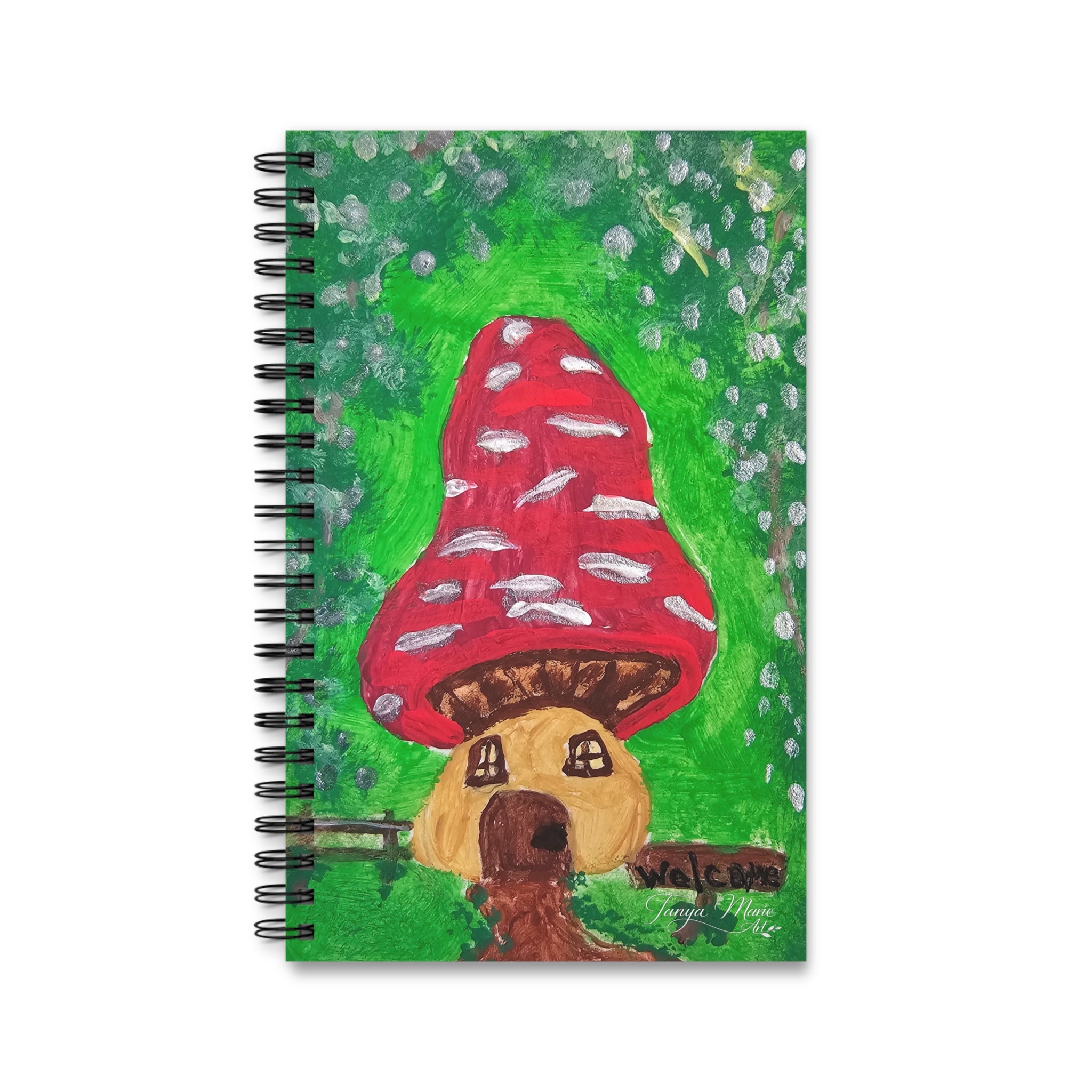 Spiral notebook with red mushroom house illustration and small white dots on green cover