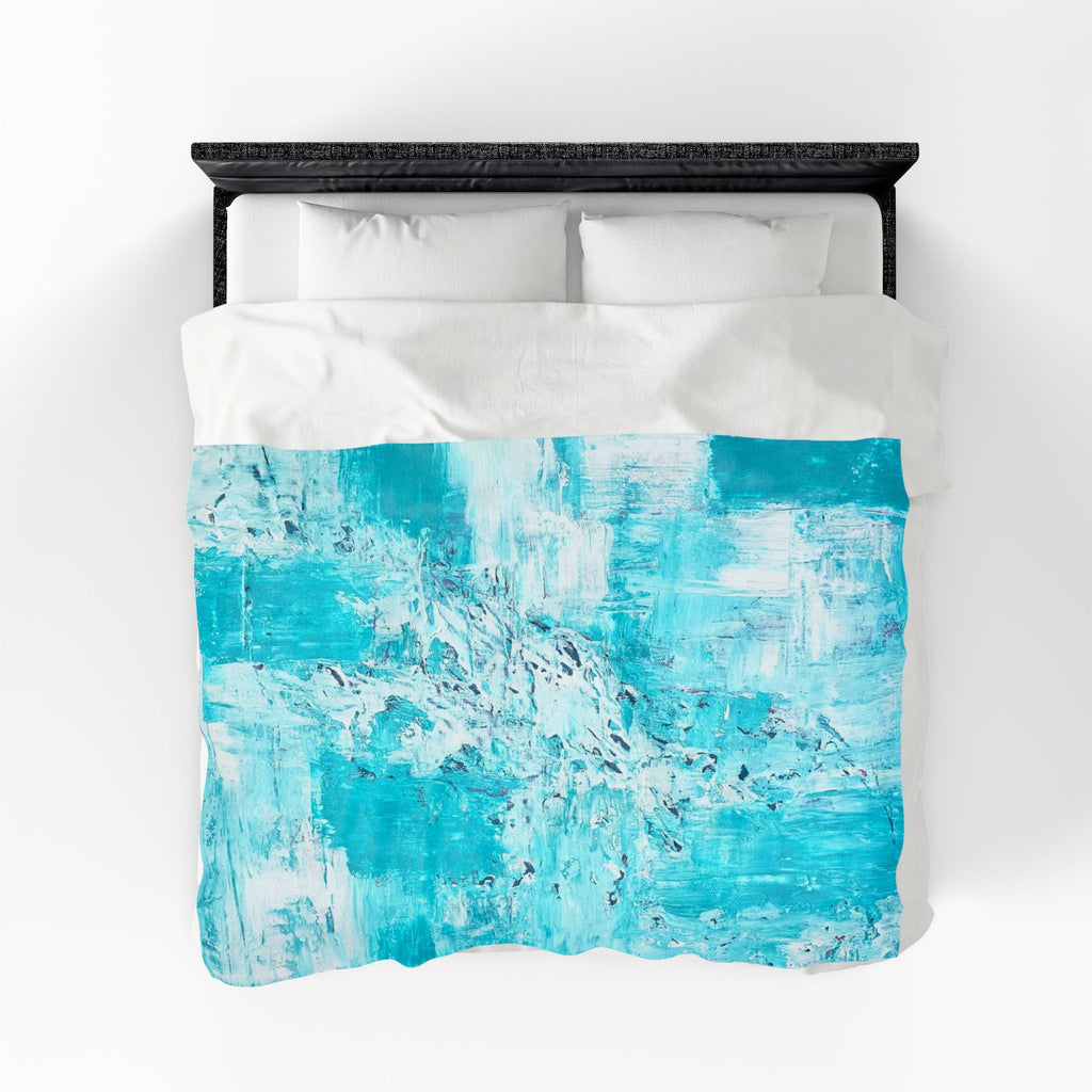 Turquoise abstract plush blanket on bed, centered on white bedding