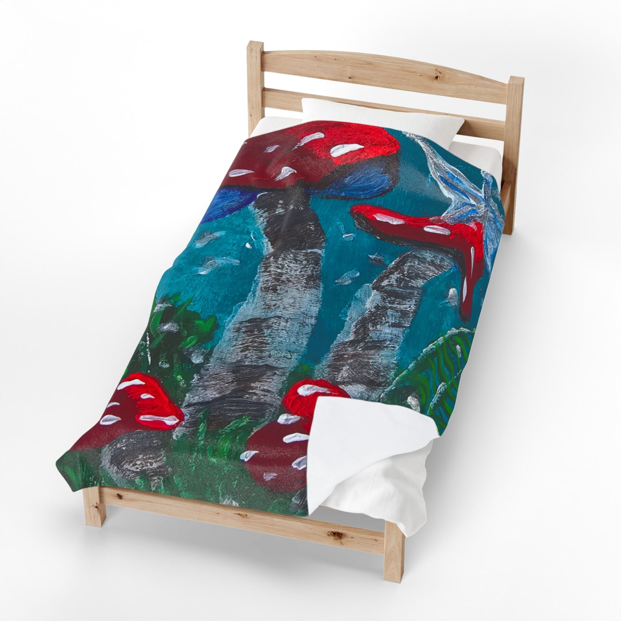 Velveteen plush blanket laid on a bed frame, mushroom print with red caps and teal blues