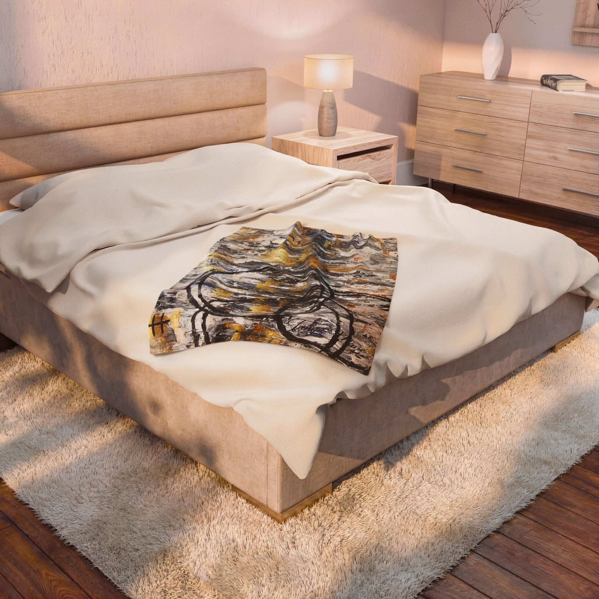 Velveteen plush blanket with abstract gold and charcoal circle design on off-white