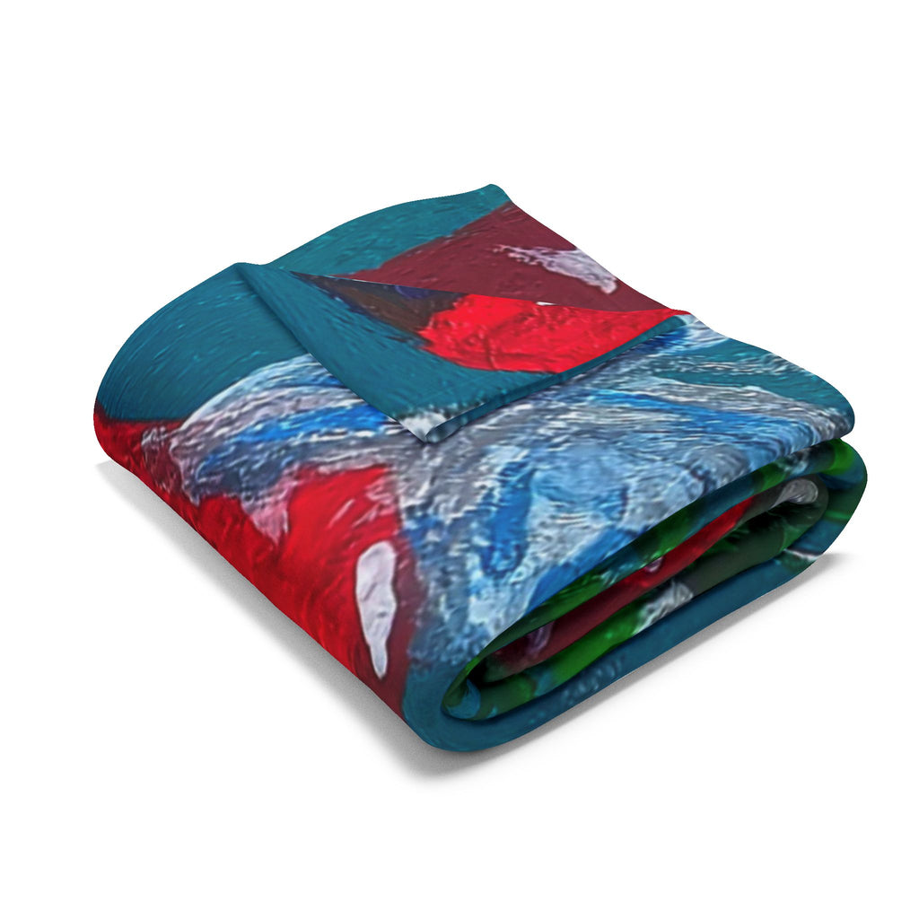 Fleece blanket folded with teal and blue artwork, featuring red mushroom caps and green accents