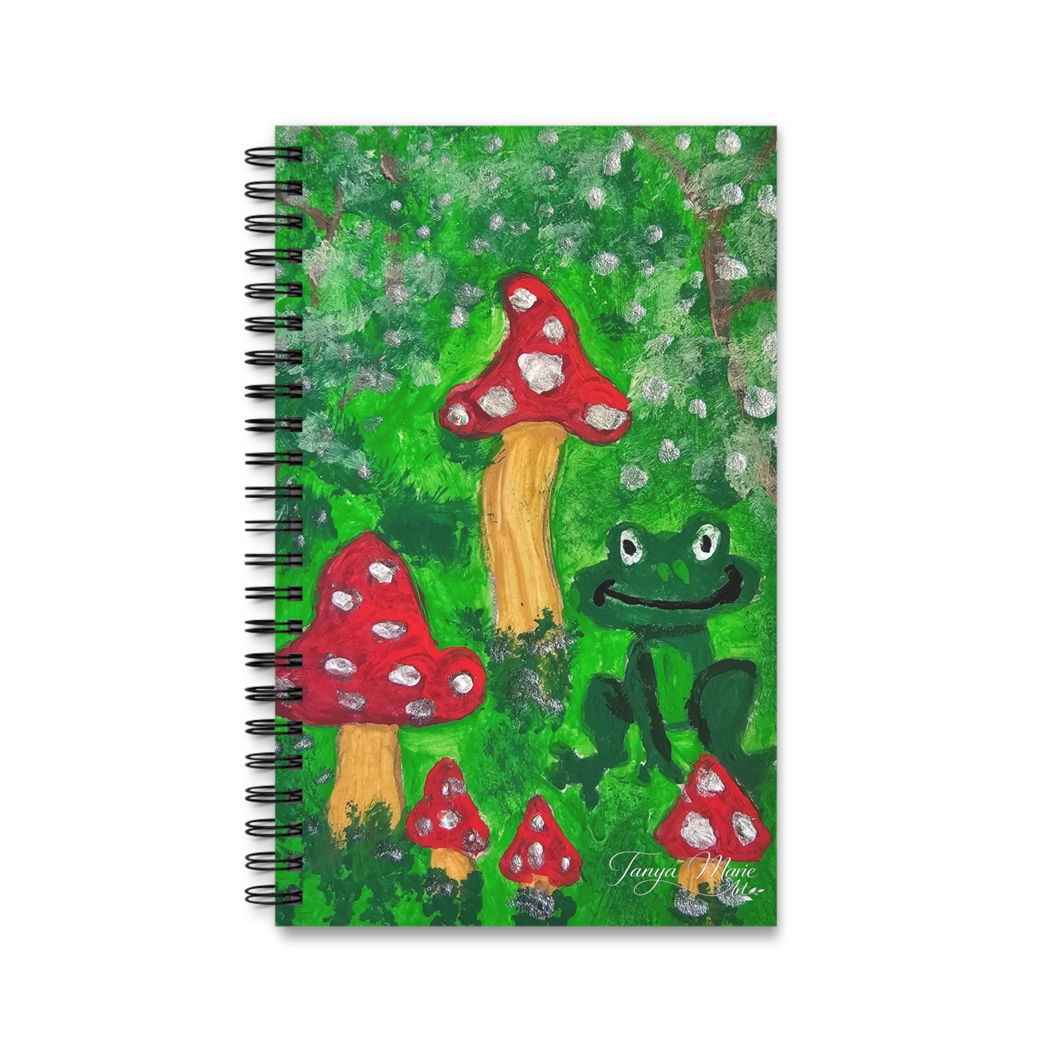 Spiral journal with green illustrated cover of red mushrooms, speckles, and a frog.