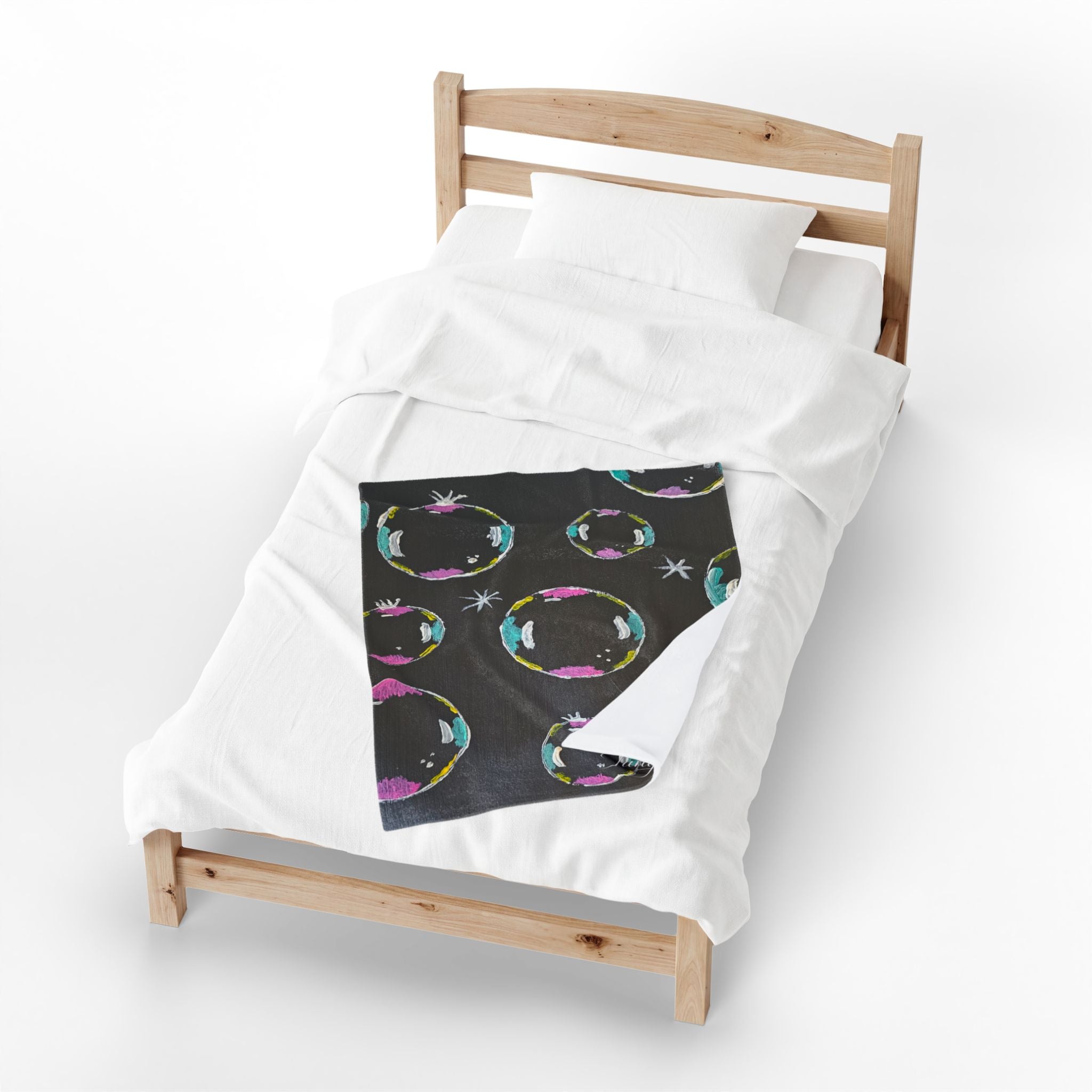 Plush blanket on bed frame, dark panel with multicolor bubble circles