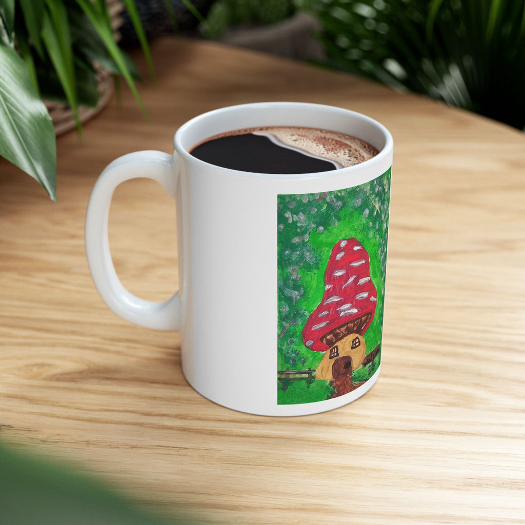 White ceramic mug with red mushroom house artwork and filled coffee inside