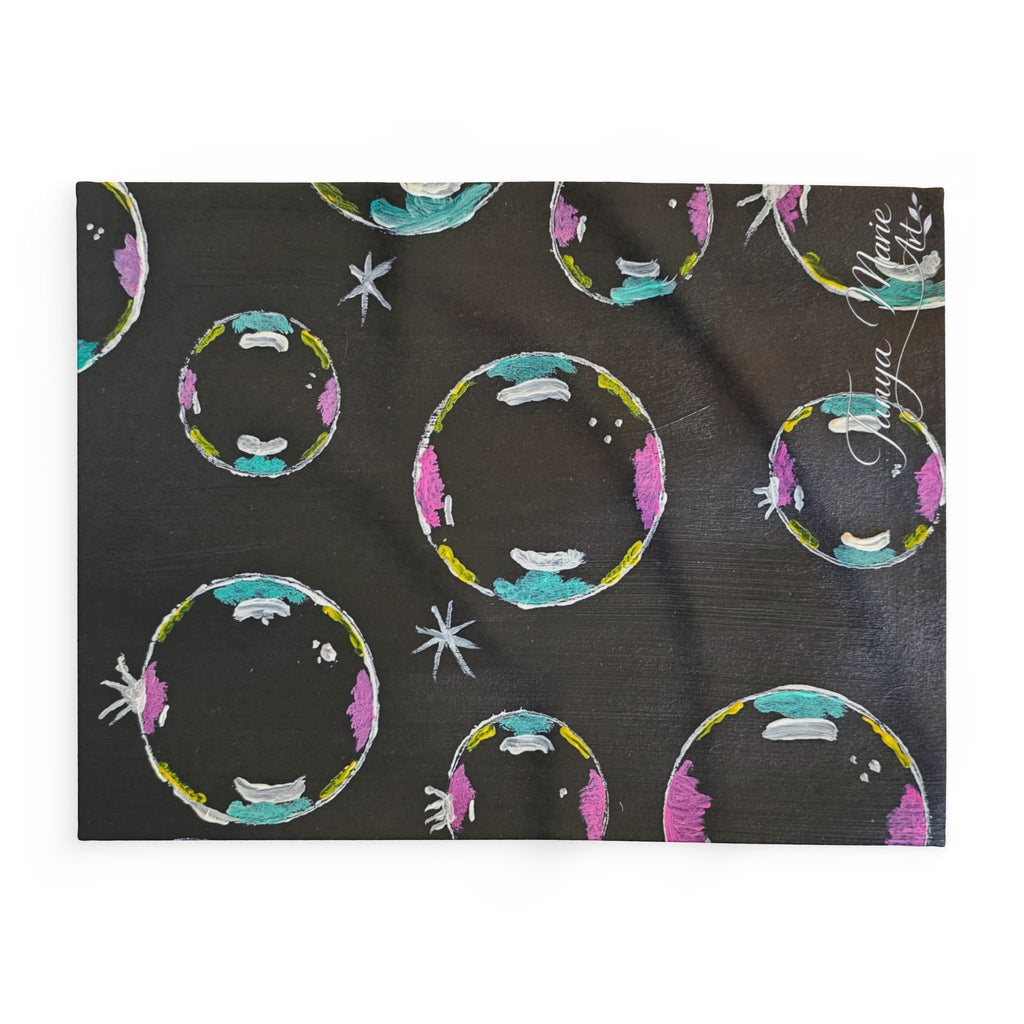 Fleece throw blanket close-up, dark base with colorful circular bubbles and star details