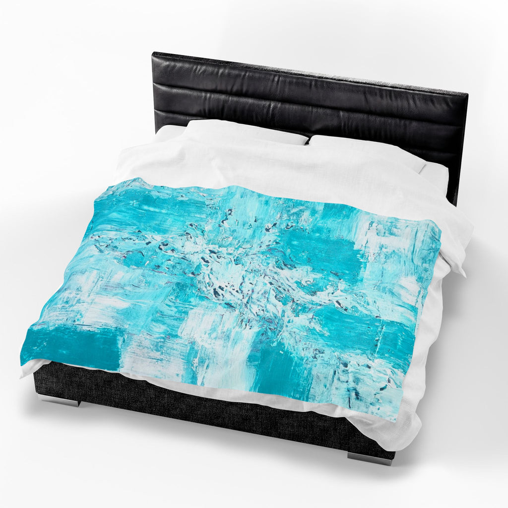 Turquoise abstract plush blanket on black bed, paired with white bedding