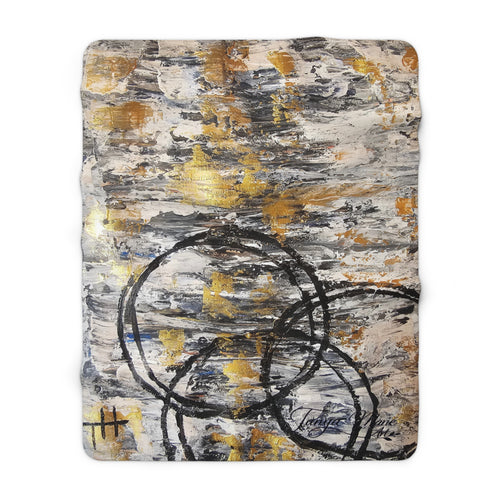 Rectangular sherpa blanket with abstract gold, gray, and charcoal circular line artwork