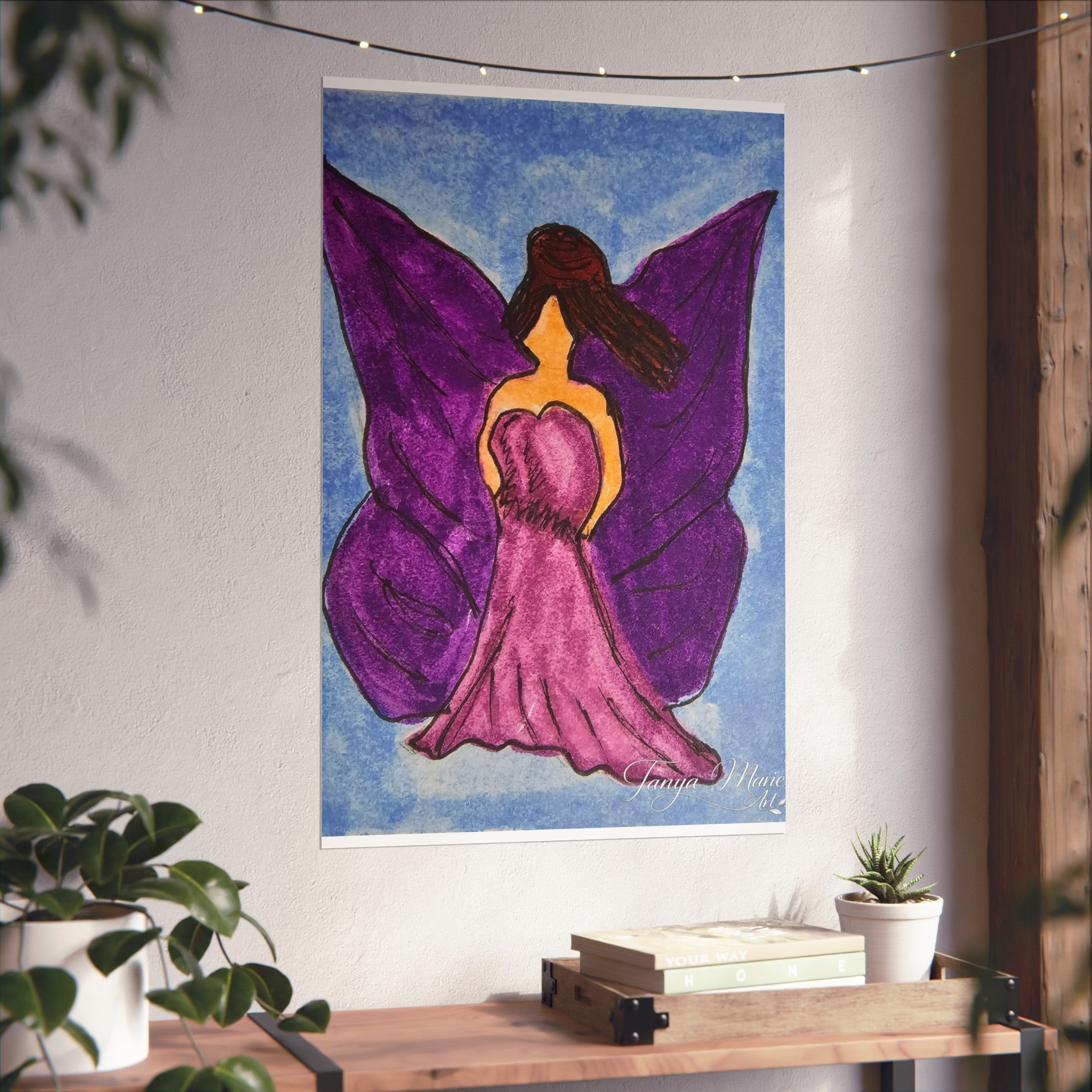 Purple wings angel wall art print on a wall above a wooden shelf with decor items
