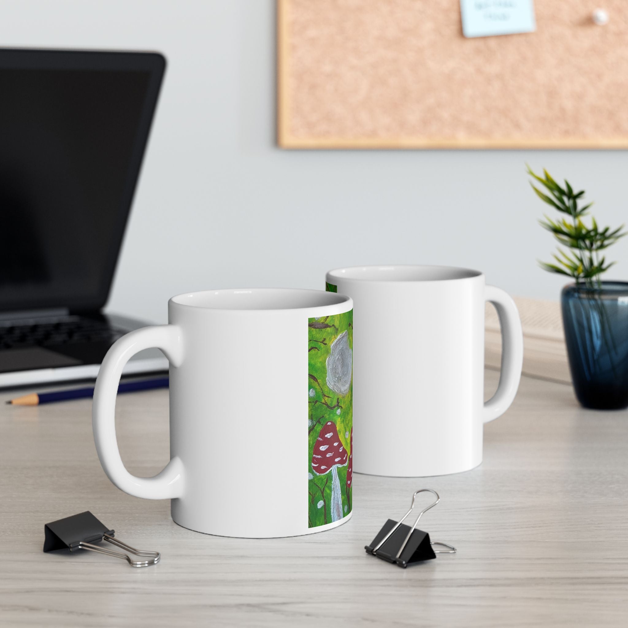 Set of two white ceramic mugs with green woodland and red toadstool artwork panels