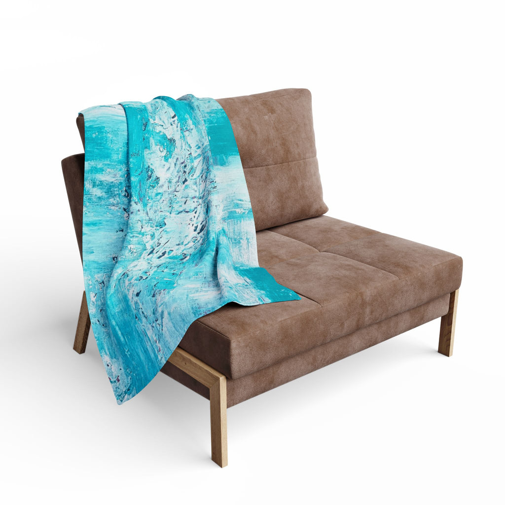 Turquoise abstract fleece blanket draped over chair arm, splash-streak pattern