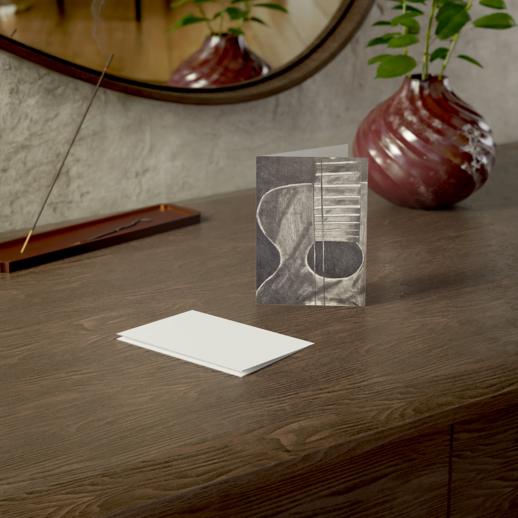 Blank note card featuring a monochrome acoustic guitar sketch on the cover, white