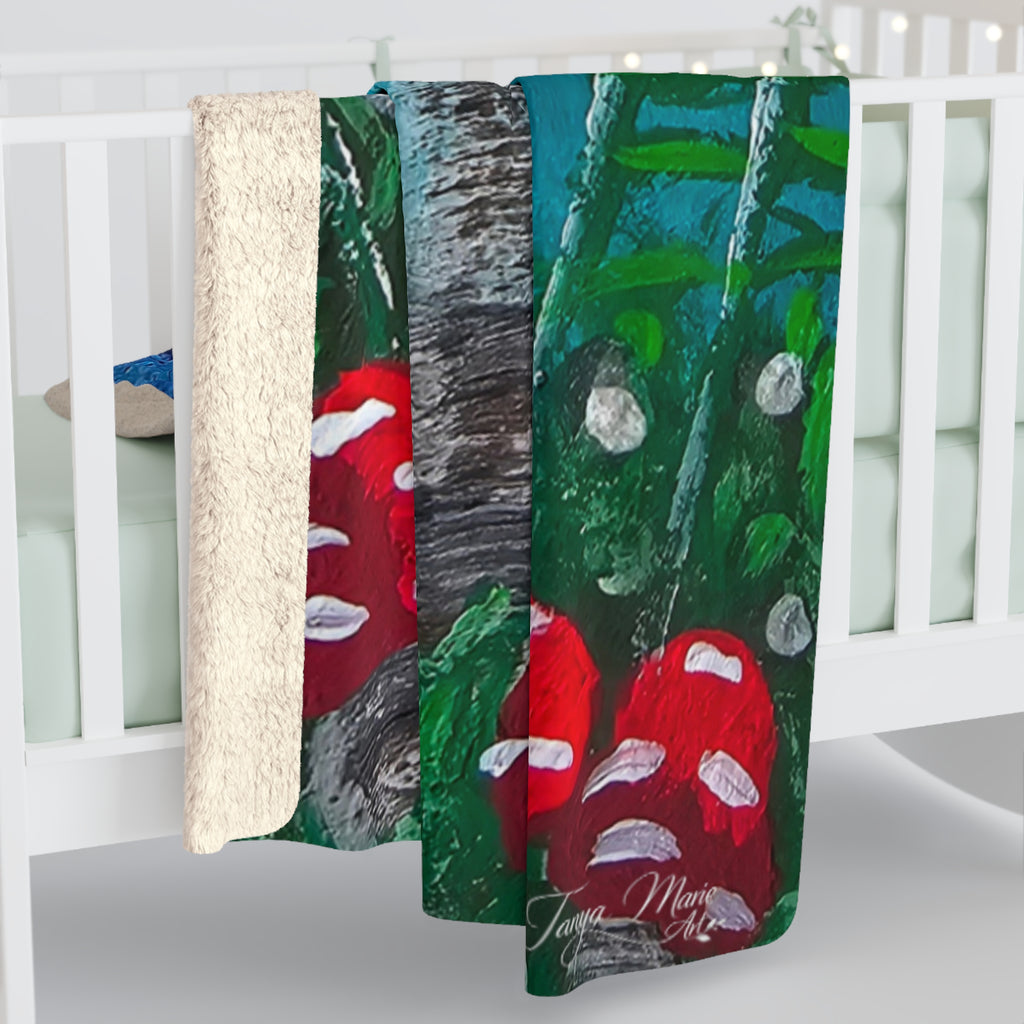 Sherpa blanket draped over crib rail, green and blue mushroom print with red toadstools.