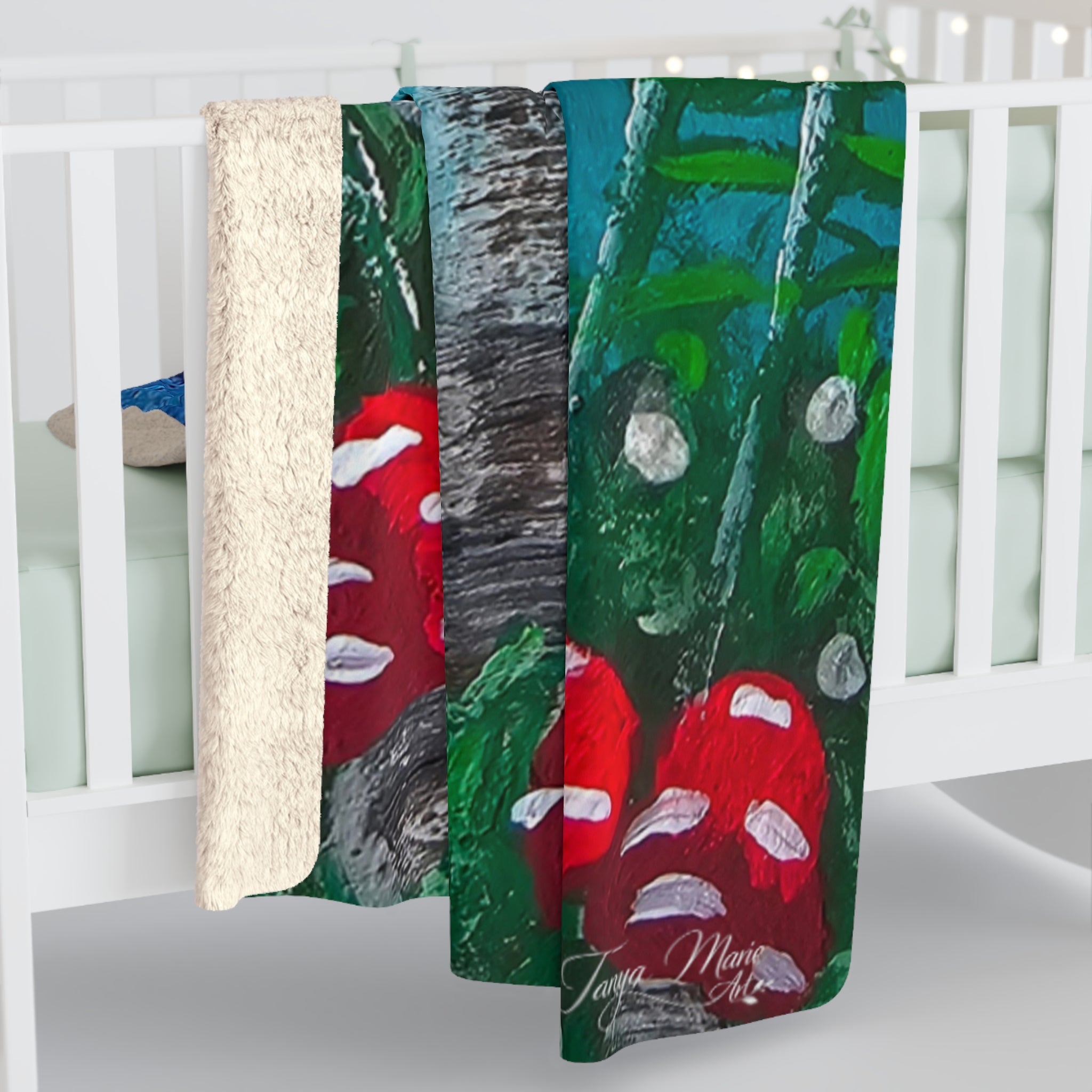 Sherpa blanket draped over crib rail, green and blue mushroom print with red toadstools.