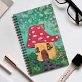 Spiral journal with mushroom cottage cover in green background and red mushroom cap.