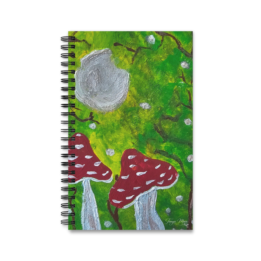 Spiral journal notebook front cover showing green forest, gray moon, and two red mushrooms
