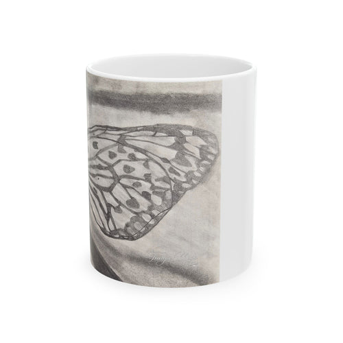 White ceramic mug with butterfly wing sketch wrapping the front, side handle visible