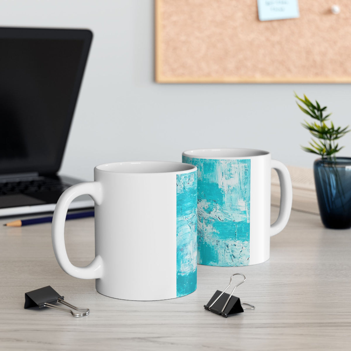 Two white ceramic mugs with turquoise abstract side panels and handles