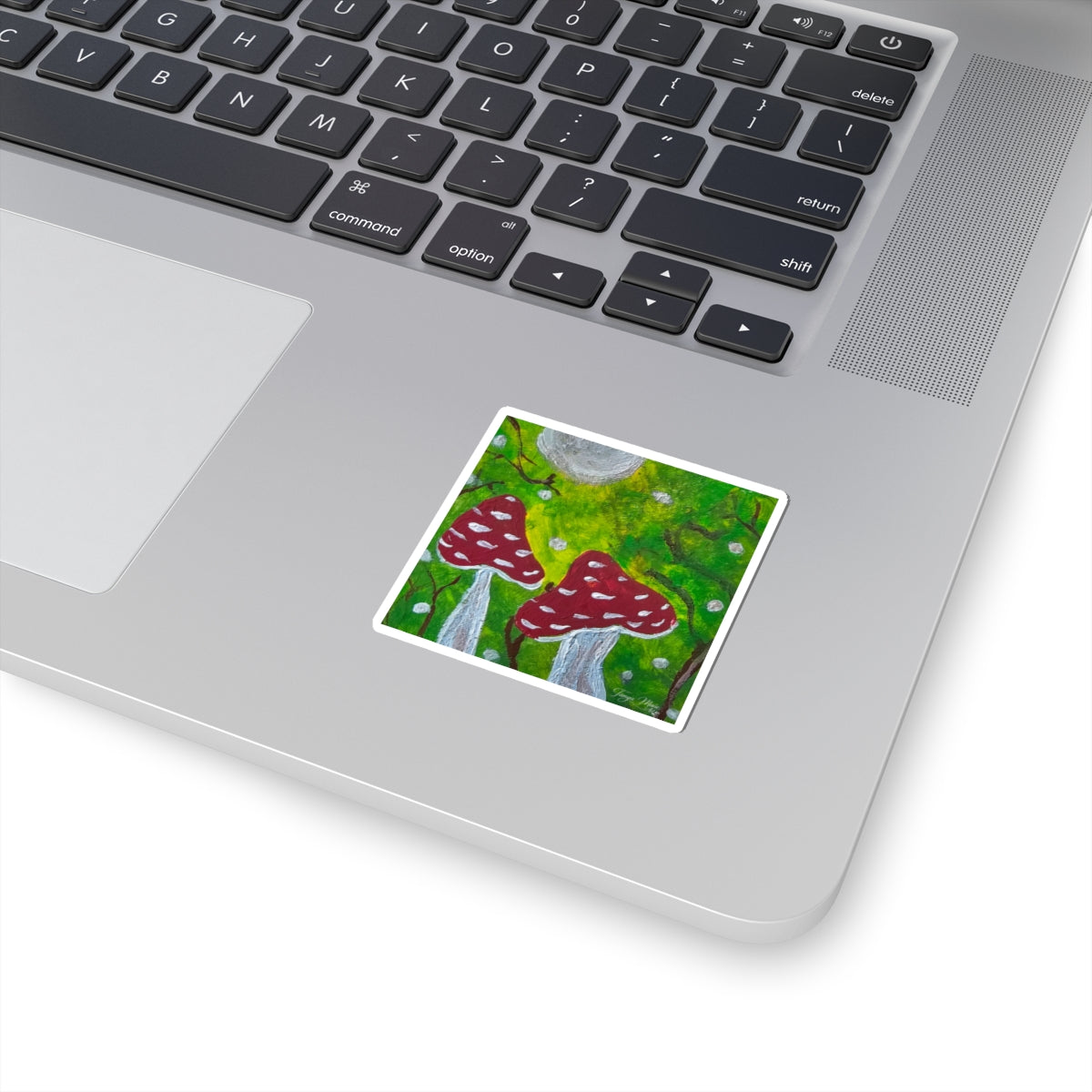 Kiss-cut sticker with red toadstools and green forest background, white border.