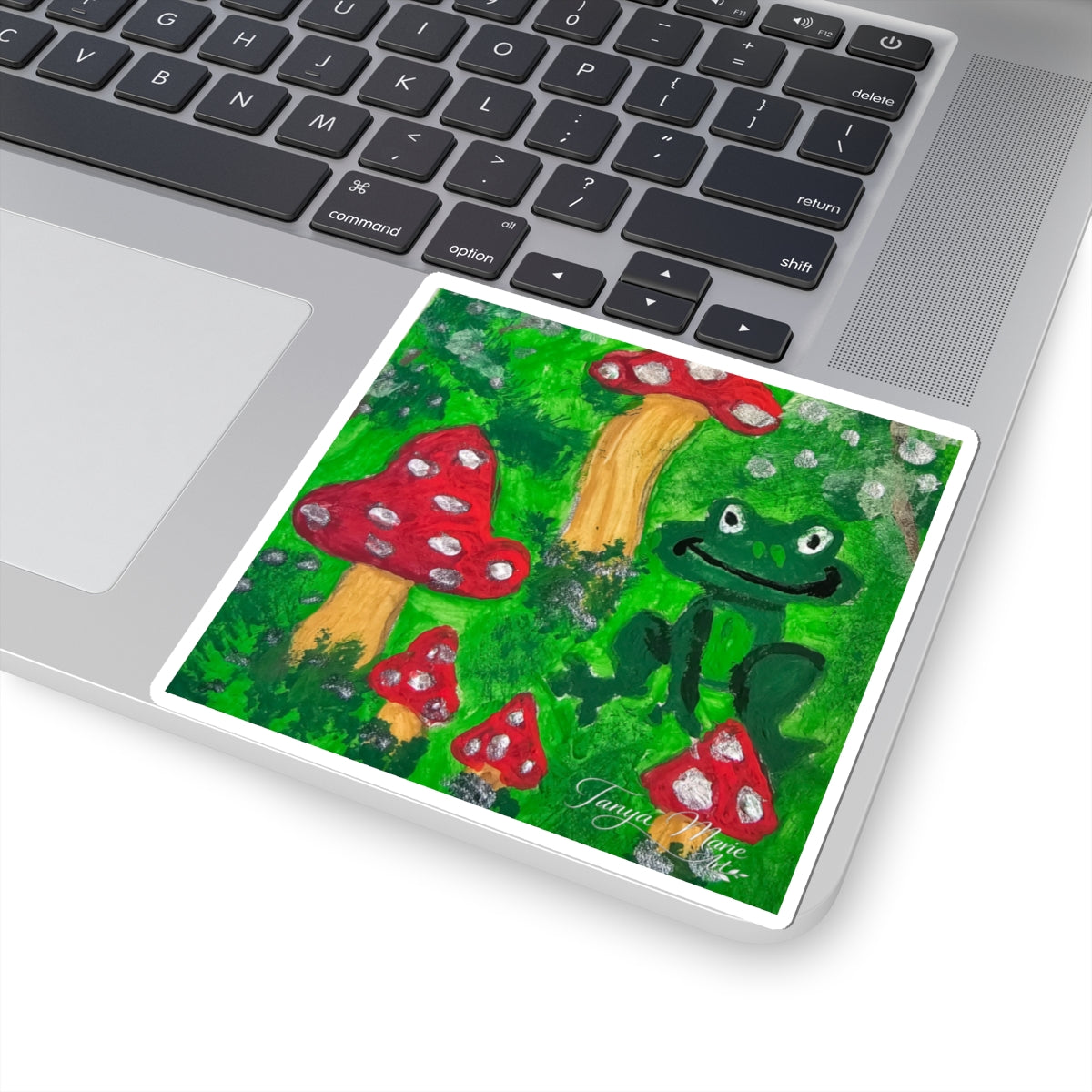 Kiss-cut rectangular sticker depicting a green frog and red toadstools, white border