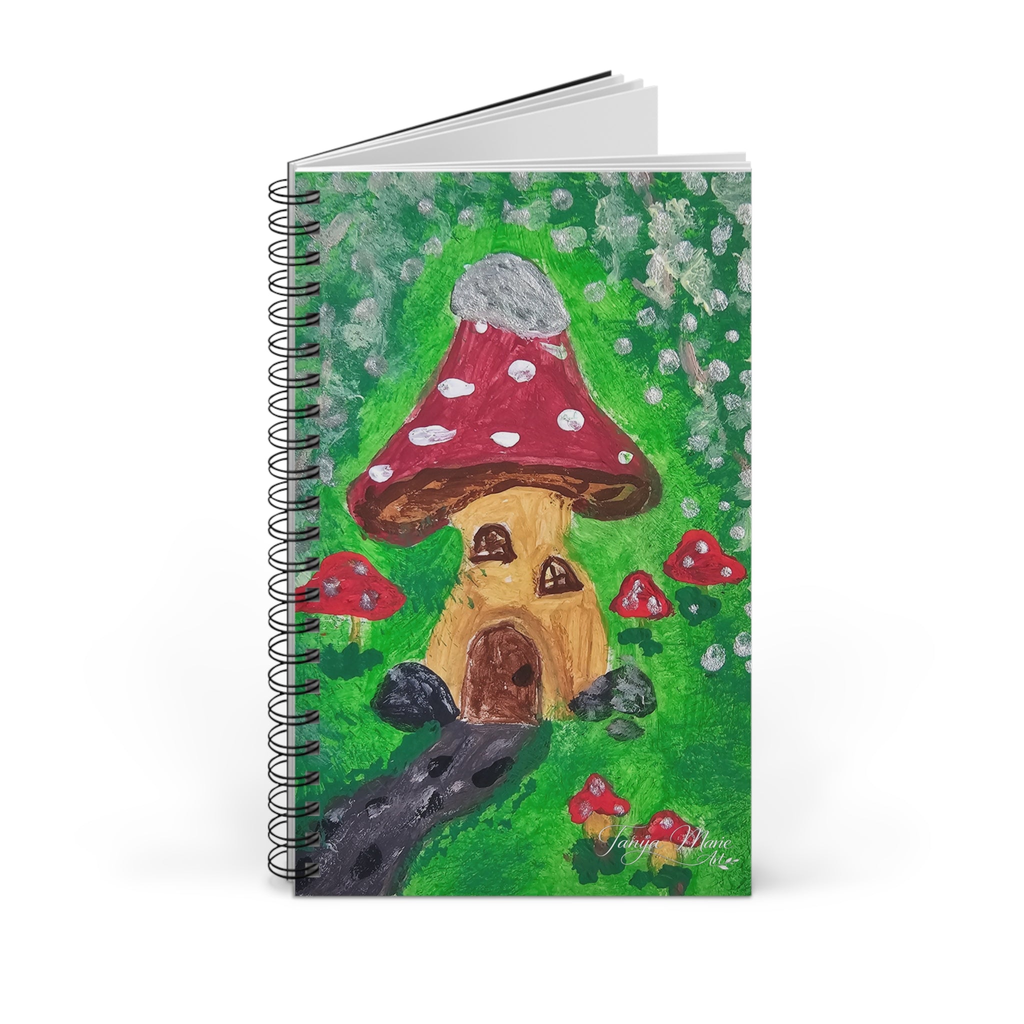 Spiral journal notebook showing mushroom house fairy garden cover with extra white sheets behind.