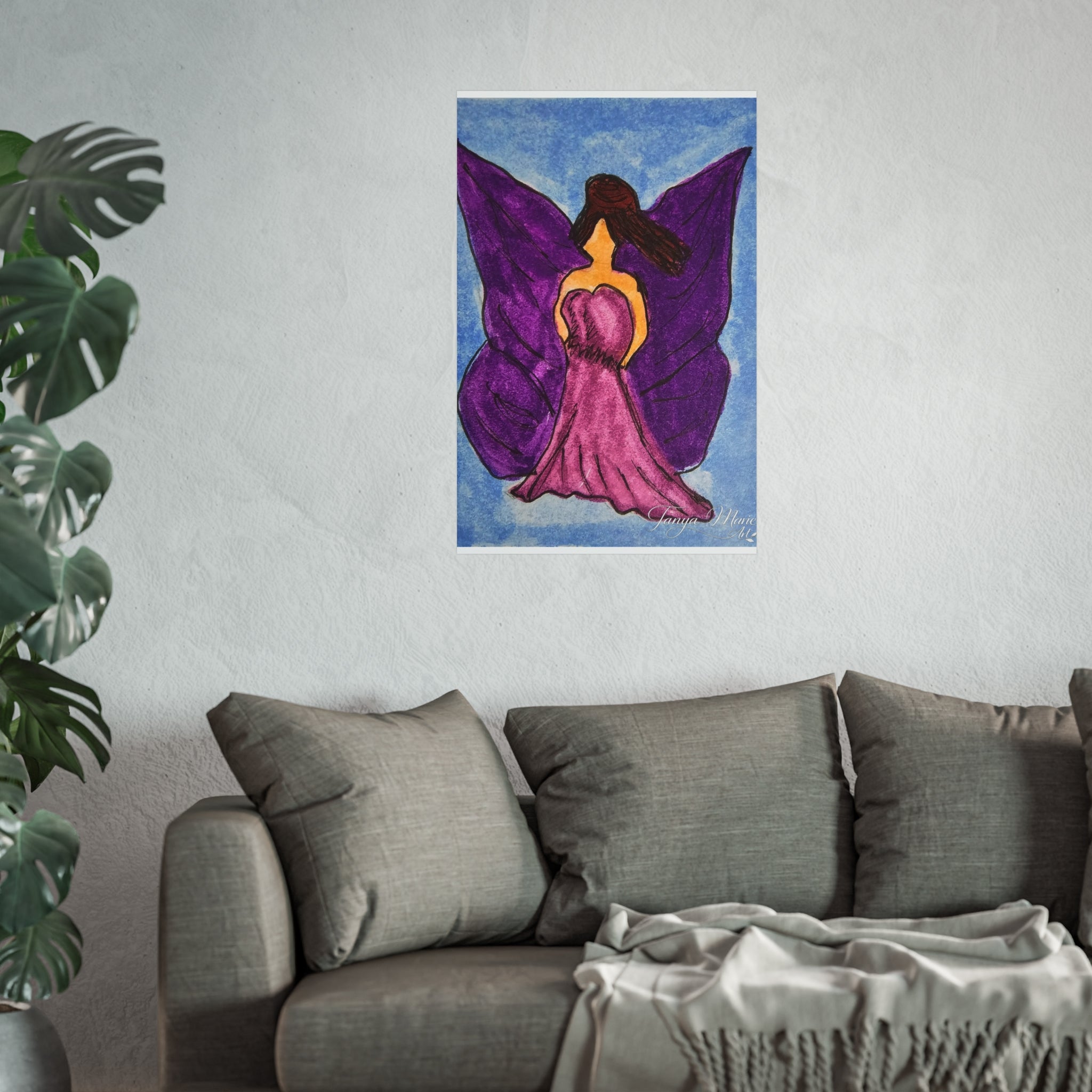 Purple wings angel wall art print hanging on a wall above a gray sofa and throw blanket