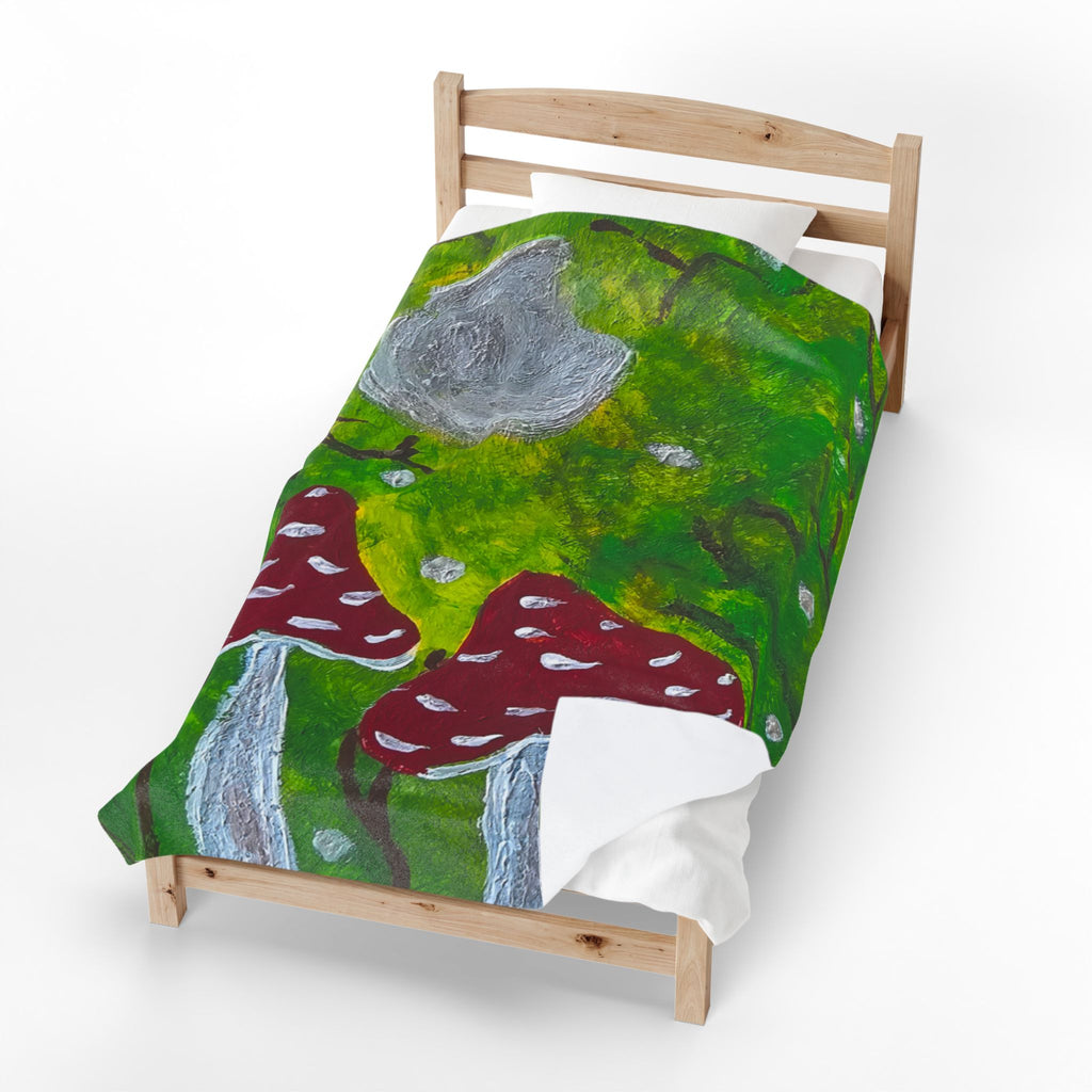 Plush velveteen blanket on bed, green forest art with red mushrooms and gray stones