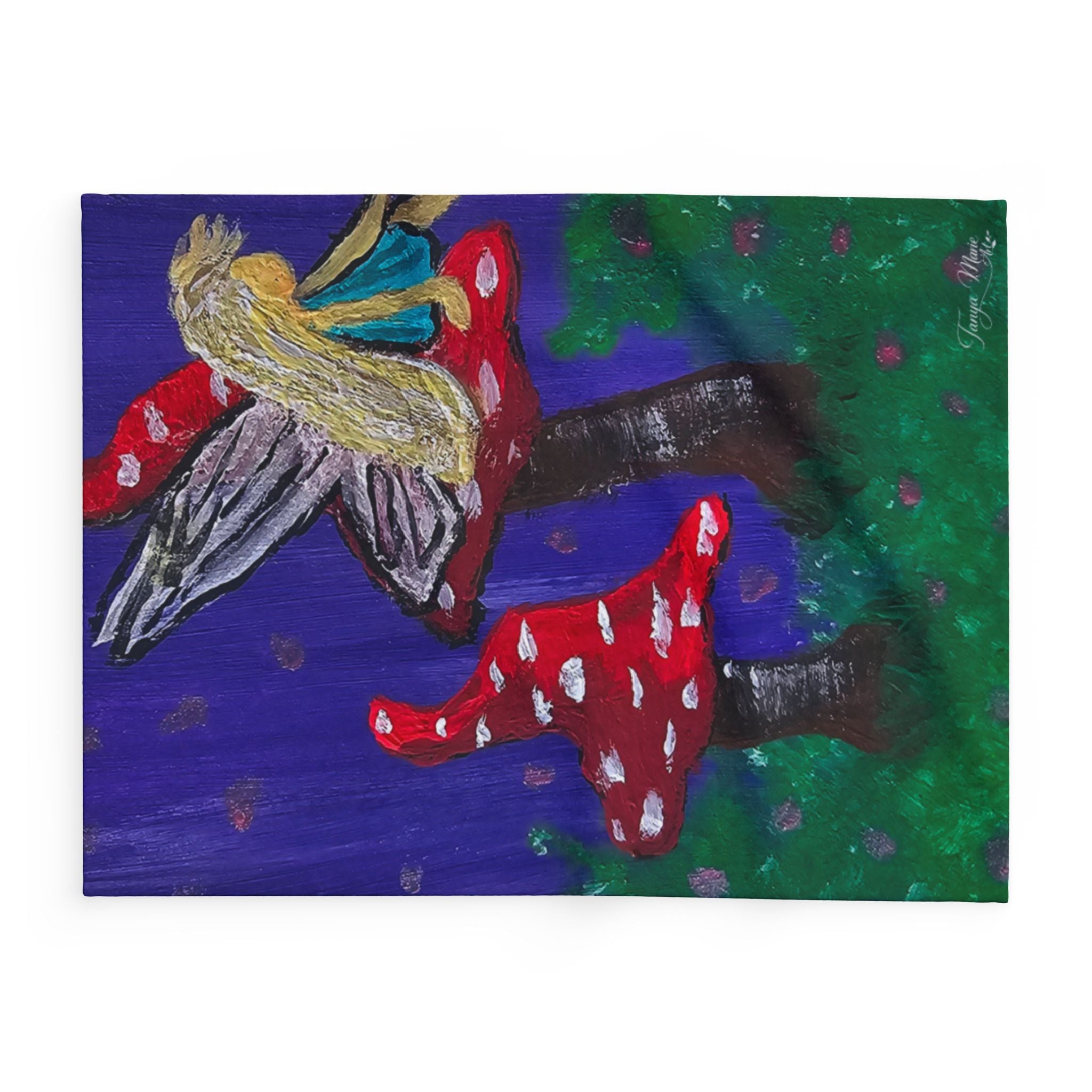 Close-up of fleece blanket artwork featuring fairy with wings and red-spotted mushrooms