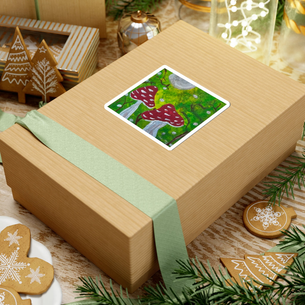 Kiss-cut sticker on gift box lid, red toadstools over green moss with small white dots.