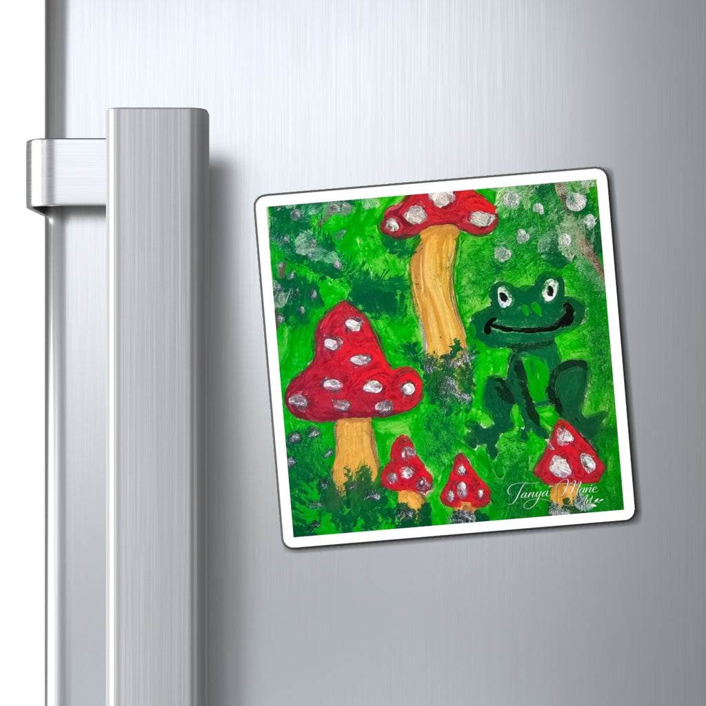 Rectangular fridge magnet featuring green frog and red mushrooms with white frame